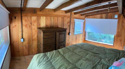 a bedroom in a log cabin with a bed and a window at A Modo Mío in San Carlos de Bariloche