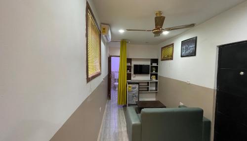 ein Wohnzimmer mit einem Sofa und einem Deckenventilator in der Unterkunft Wisdom Villa in Kumasi