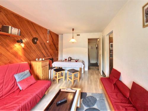 un salon avec un canapé rouge et une table dans l'établissement Studio confortable skis aux pieds avec balcon, piscine chauffée - FR-1-267-242, à Villarembert