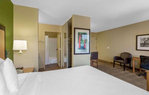 a hotel room with a bed and a desk and chairs at Extended Stay America Suites - Boston - Burlington in Burlington