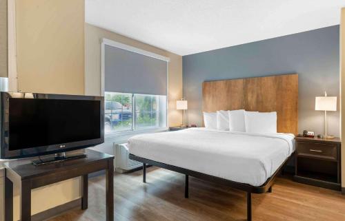 a bedroom with a bed and a flat screen tv at Extended Stay America Suites - Boston - Burlington in Burlington