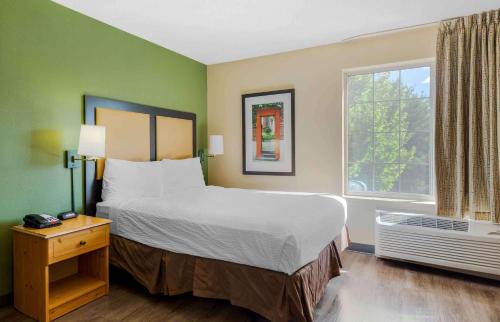 een slaapkamer met een groot bed en een raam bij Extended Stay America Suites - Boston - Waltham - 52 4th Ave in Waltham
