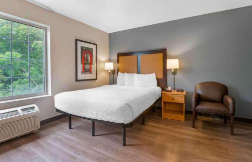 a bedroom with a bed and a chair and a window at Extended Stay America Suites - Hanover - Parsippany in Whippany