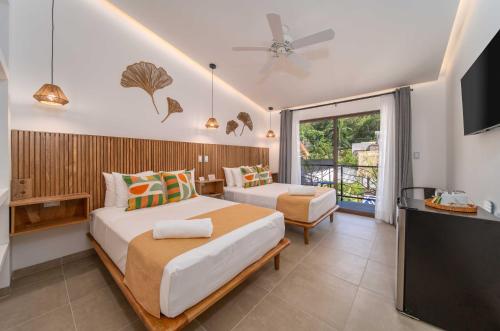 a bedroom with two beds and a flat screen tv at Casa Blú Huatulco in Santa Cruz Huatulco