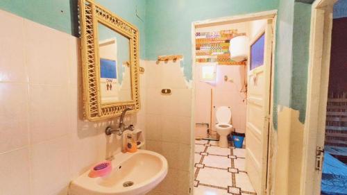 a bathroom with a sink and a mirror and a toilet at هوستل أجبناخ إنشالي Hostel Agbenakh Inshaly in Siwa