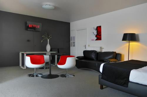 a bedroom with a bed and a table and two chairs at Hotel Adoma in Ghent