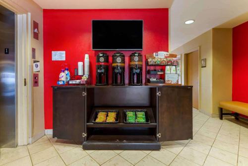 a liquor cabinet with a tv on a red wall at Extended Stay America Suites - Piscataway - Rutgers University in Randolphville