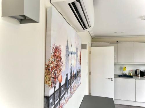 a kitchen with a large painting on the wall at Luxurious 2 Bedroom flat in Central London in London