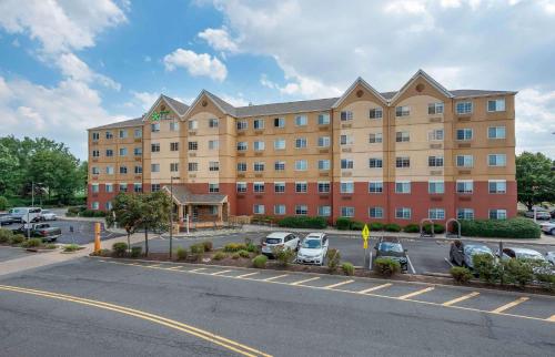 a large building with cars parked in a parking lot at Extended Stay America Suites - Secaucus - New York City Area in Secaucus