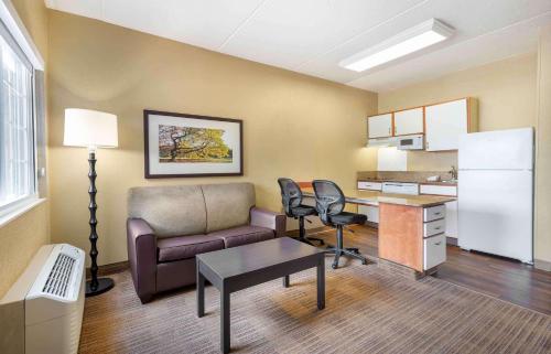 a living room with a couch and a desk with chairs at Extended Stay America Suites - Secaucus - New York City Area in Secaucus