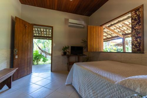 a bedroom with a bed and a large window at Pousada Villa Mares in Barra Grande