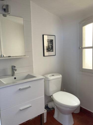une salle de bain blanche avec des toilettes et un lavabo dans l'établissement La Maison sur les Toits, à Aix-en-Provence