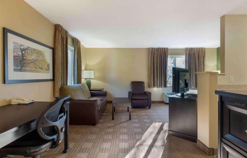 ein Hotelzimmer mit einem Schreibtisch und einem Wohnzimmer in der Unterkunft Extended Stay America Suites - Hartford - Farmington in Farmington