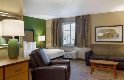 ファーミントンにあるExtended Stay America Suites - Hartford - Farmingtonのベッドとソファ付きのホテルルーム