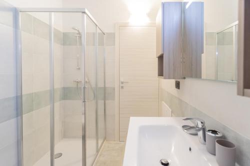 a bathroom with a white sink and a shower at ANNA'S LODGE QUITE & CHARME in Pianello Del Lario