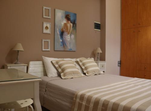 a bedroom with a bed with a painting on the wall at Olive Villa Crete in Rethymno Town