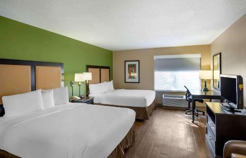 Habitación de hotel con 2 camas, escritorio y TV. en Extended Stay America Suites - Norwalk - Stamford en Norwalk