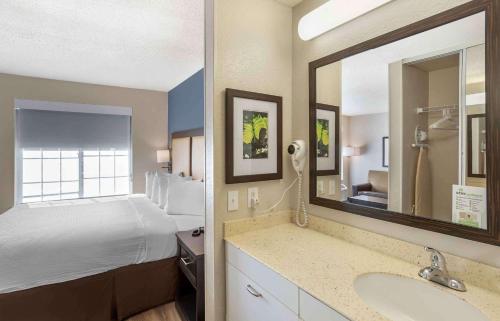 a hotel room with a bed and a bathroom with a sink at Extended Stay America Suites - Norwalk - Stamford in Norwalk