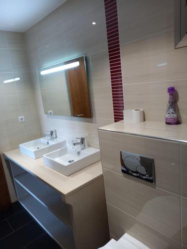a bathroom with two sinks and a mirror at Portela susa in Portela Susã