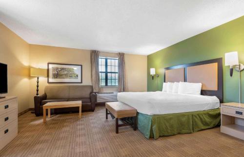 a hotel room with a large bed and a couch at Extended Stay America Suites - Buffalo - Amherst in Amherst