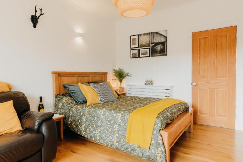 1 dormitorio con 1 cama y 1 sofá en Luxury Private Suite-Parking, Courtyard & Wi-Fi en Caldicot