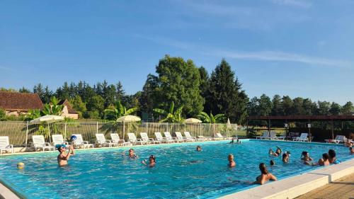 un groupe de personnes dans une piscine dans l'établissement Le Domaine du Bois Coquet, à La Douze