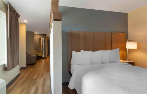 a bedroom with a large white bed with a wooden headboard at Extended Stay America Premier Suites - Providence - East Providence in East Providence