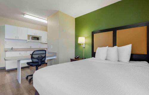 a hotel room with a bed and a desk and a chair at Extended Stay America Suites - Syracuse - Dewitt in East Syracuse
