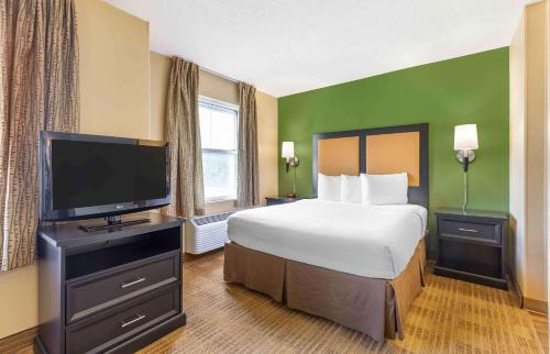 a hotel room with a bed and a flat screen tv at Extended Stay America Suites - Washington, DC - Gaithersburg - South in Gaithersburg