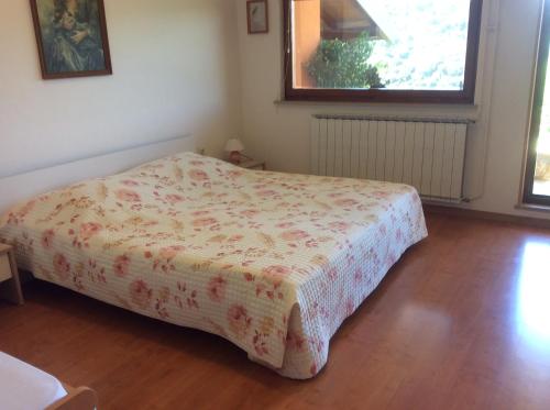 ein Schlafzimmer mit einem Bett mit einer Blumendecke darauf in der Unterkunft Apartments Krt Mirko in Izola