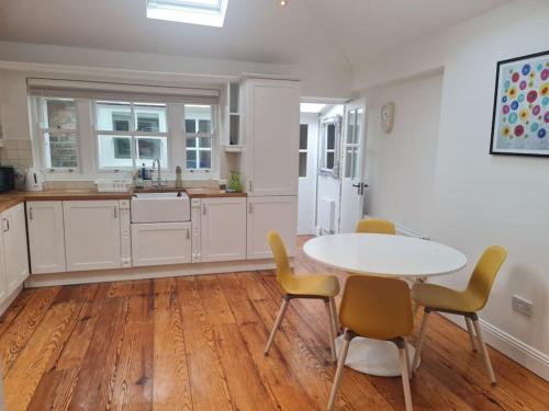 a kitchen with a table and chairs in a room at Cosy Irish Cottages RDS in Dublin