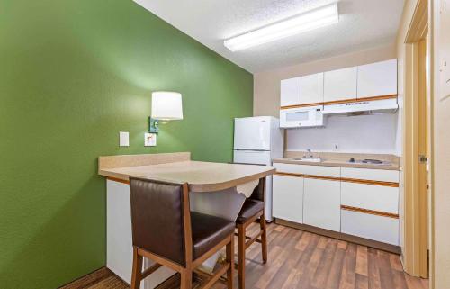 a kitchen with green walls and a table and chairs at Extended Stay America Suites - Washington, DC - Chantilly in Chantilly