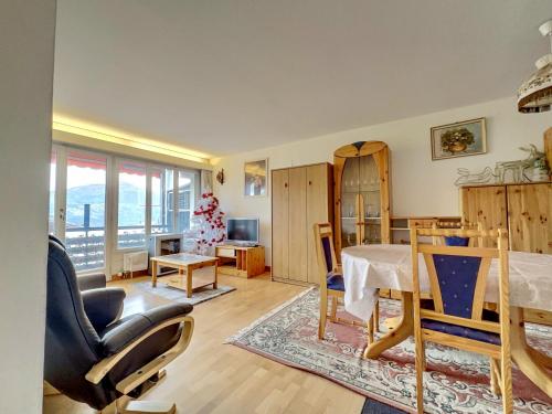 a living room with a table and a chair at Appartement l Magnifique vue l Proche Crans-Montana in Crans-Montana