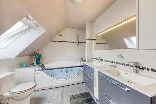een badkamer met een bad, een toilet en een wastafel bij Loft à 15 min des Champs-Élysées Paris avec parking in Clichy