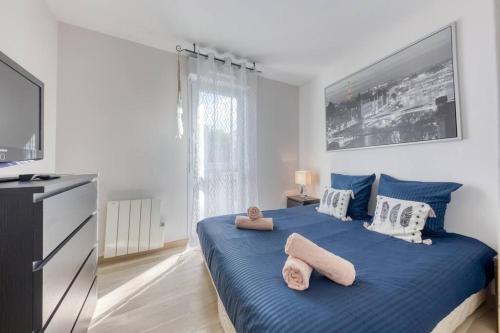 een slaapkamer met een blauw bed en handdoeken bij Loft à 15 min des Champs-Élysées Paris avec parking in Clichy