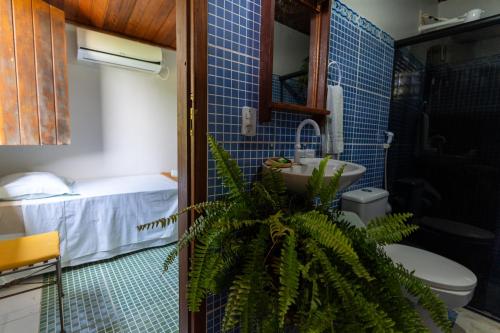 a bathroom with a sink and a toilet and a plant at Pousada Villa Mares in Barra Grande