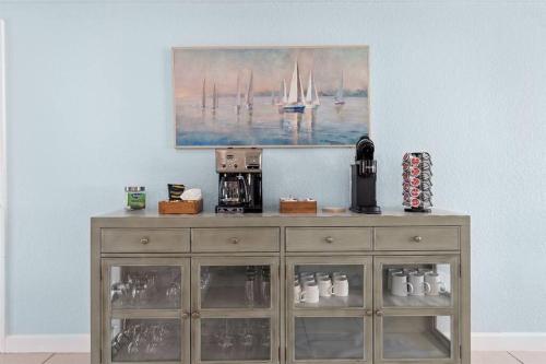 a wooden cabinet in a room with a painting on the wall at Waterfront oasis with NEW POOL and kayaks in Hernando Beach