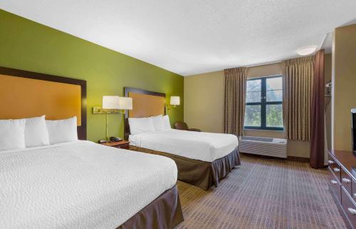 Extended Stay America Suites - Washington, DC - Chantilly - Dulles South في شانتيلي: غرفة فندقية بسريرين ونافذة
