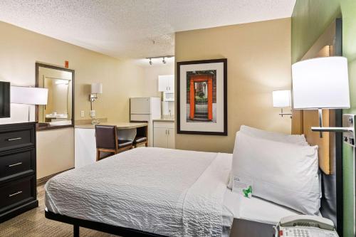 a small hotel room with a bed and a kitchen at Extended Stay America Suites - Washington, DC - Reston in Herndon