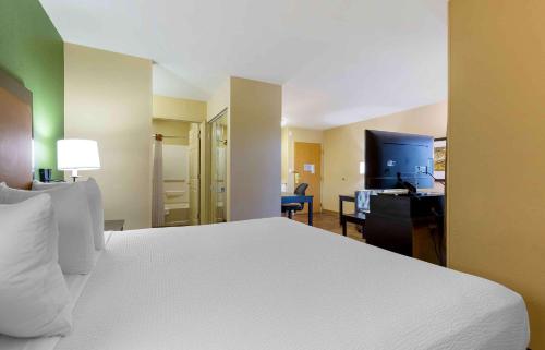 a hotel room with a bed and a desk and a bedroom at Extended Stay America Suites - Washington, DC - Fairfax in Fairfax