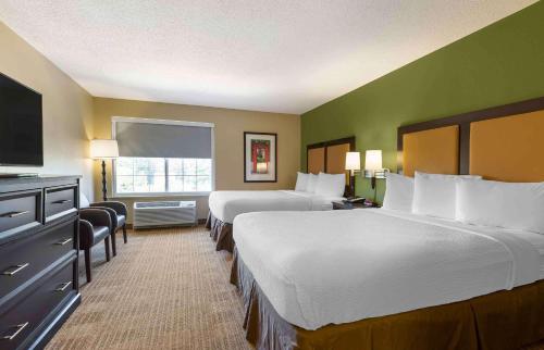 a hotel room with two beds and a flat screen tv at Extended Stay America Suites - Washington, DC - Tysons Corner in Tysons Corner