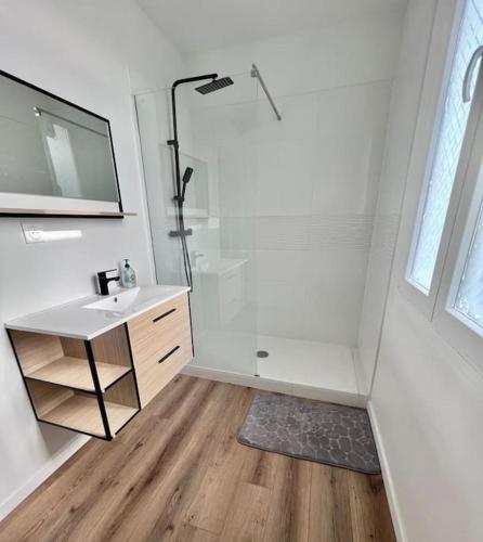 een witte badkamer met een douche en een wastafel bij Duplex Villemoisson sur orge avec jardin in Villemoisson-sur-Orge