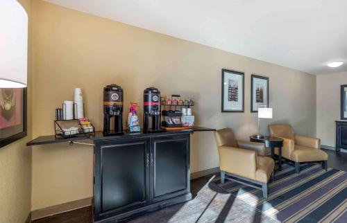 Extended Stay America Suites - Des Moines - West Des Moines في Clive: وجود بار في غرفة الفندق مع الكراسي والمشروبات