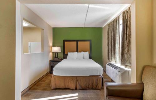 a bedroom with a bed and a green wall at Extended Stay America Suites - Des Moines - West Des Moines in Clive