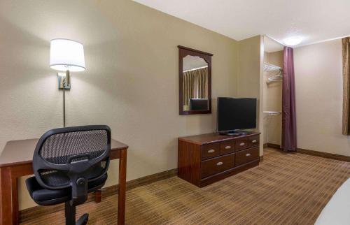 a room with a desk and a chair and a television at Extended Stay America Suites - Champaign - Urbana in Champaign