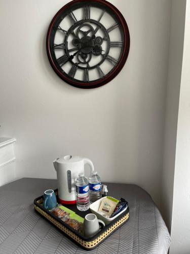 a tray with a coffee maker and a clock on a wall at La petite Irlande in Auderville