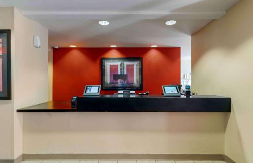 a lobby with a reception desk with a red wall at Extended Stay America Suites - Chicago - Gurnee in Gurnee