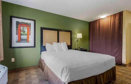 a large bed in a hotel room with green walls at Extended Stay America Suites - Chicago - Gurnee in Gurnee