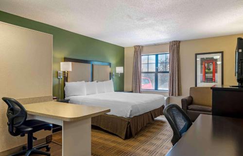 a hotel room with a bed and a table and chairs at Extended Stay America Suites - Chicago - Gurnee in Gurnee