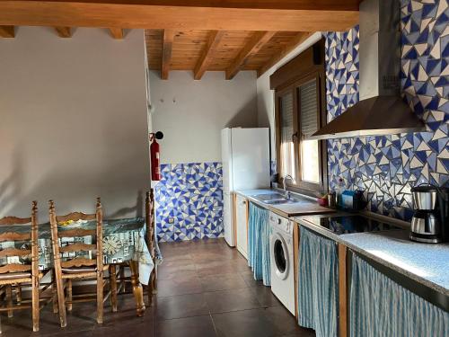 een keuken met een koelkast en een tafel en stoelen bij Higueras y Olivos in Candeleda
